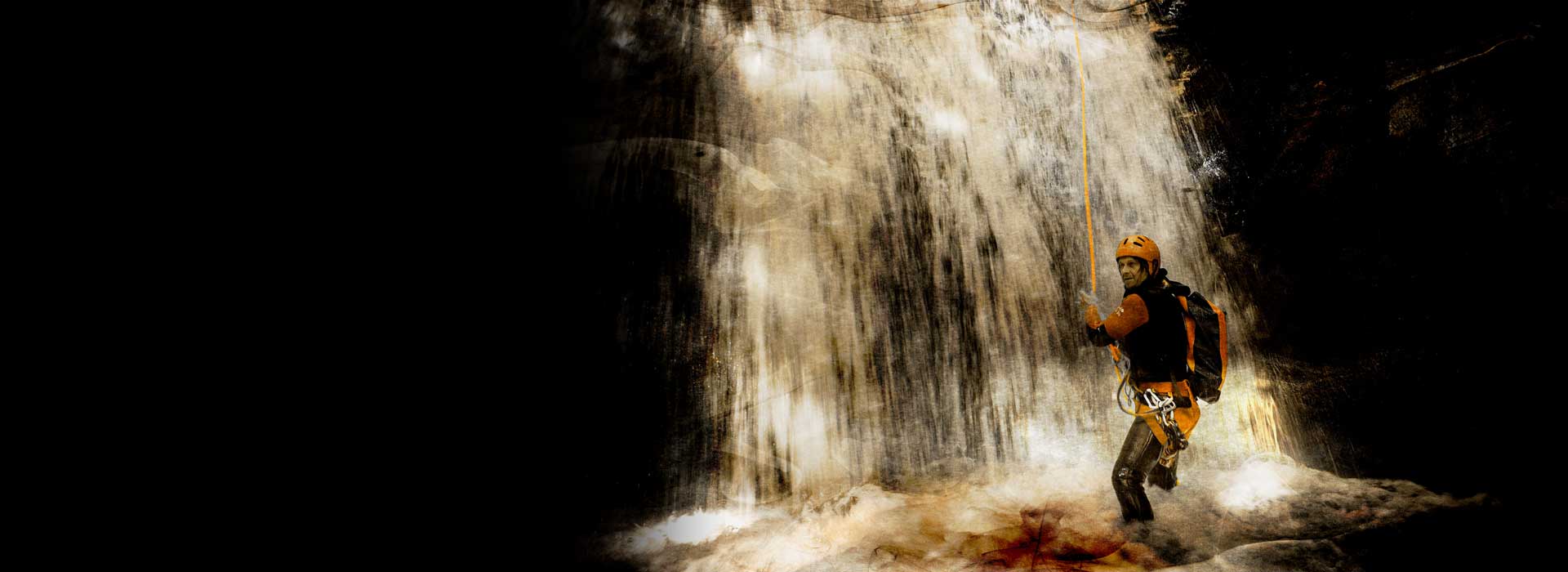 Arrival of the guide abseiling at the bottom of a waterfall in a Savoie canyon