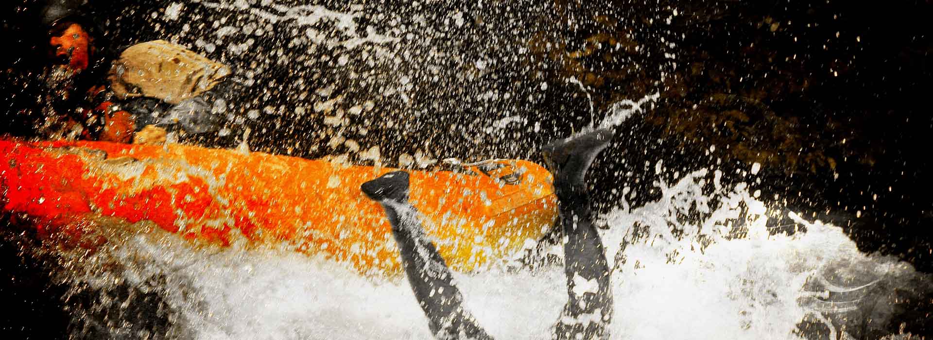 Éjection d'un homme du canoraft dans les rapides, les 2 jambes sont encore en l'air et le reste du corps dans l'eau