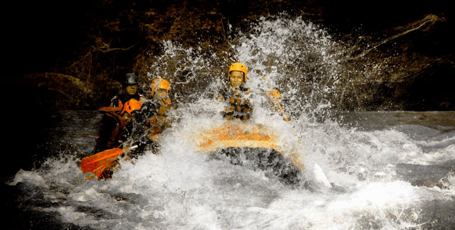 Raft en Savoie passant les rapides. C'est sportif et ça éclabousse.